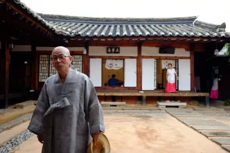 Traditionelles koreanisches Haus mit Personen in traditioneller Kleidung.