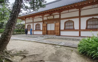 Traditionelles japanisches Gebäude mit zwei Menschen davor.